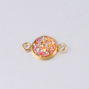 Detail of 10mm gold vacuum plated stainless steel charm with orange-pink glitter