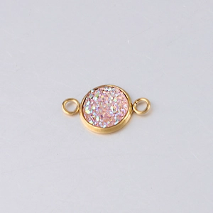Macro detail of 10mm gold stainless steel charm with pink sparkling druzy stone