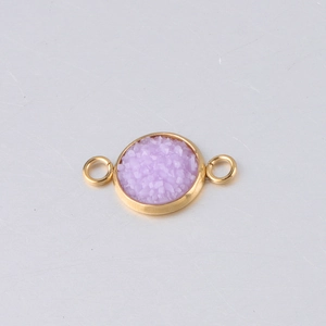 Macro shot of 10mm gold stainless steel jewelry connector with purple resin inlay