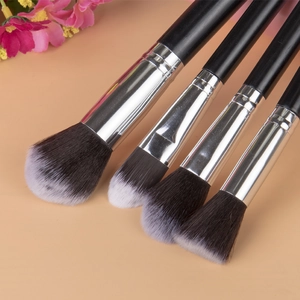 Detailed close-up of 4 professional makeup brushes with silver ferrules and soft fiber bristles