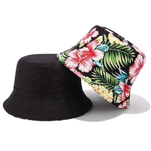 Detail of a foldable cotton bucket hat showing both solid black and tropical floral prints
