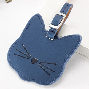 Detalle de etiqueta de equipaje de cuero azul marino en forma de gato con nariz de corazón