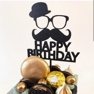 Macro detail of black acrylic Happy Birthday topper with hat, glasses and beard design
