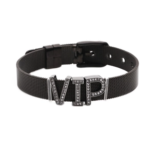 Detail eines schwarzen Mesh-Armbands aus Metall mit funkelndem VIP-Anhänger aus Strass