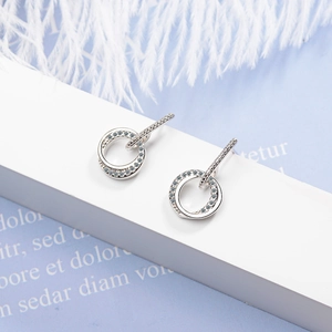 Elegant silver double-hoop earrings featuring sparkling zircons on a white geometric surface