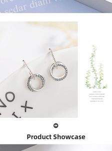 Detail of silver round hoop earrings with micro-pave blue and white crystals on a ceramic tray