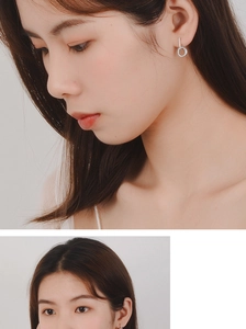 Detailed view of silver hoop earrings with shimmering cubic zirconia on model