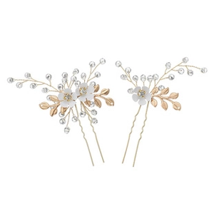 Detalle de dos horquillas para el pelo con flores blancas, hojas doradas y cristales