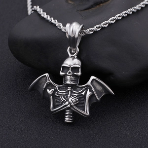 Vintage punk stainless steel skull necklace with bat wings on a black textured rock