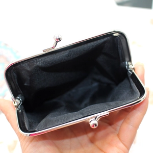 Macro shot of ethnic style coin purse showing silver metal kiss lock and black mesh interior