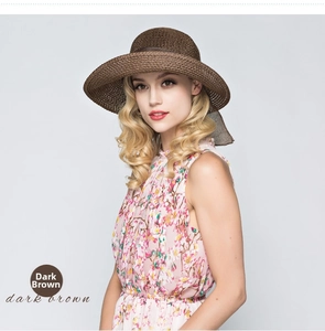 Detail of dark brown straw sun hat with decorative ribbon and wide brim for women