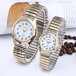 Detail of quartz couple watches with gold and silver elastic bands and numeric dials