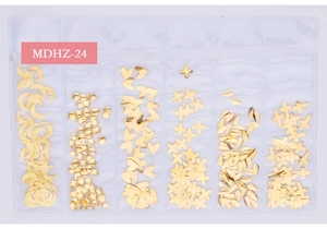 Close-up of golden metal nail art studs featuring moon, star and heart shapes in a case