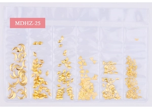 Close-up of 6-grid box containing assorted gold star and moon metal nail art charms