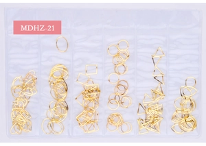 Close-up of golden hollow metal geometric shapes for DIY nail art in a 6-grid organizer