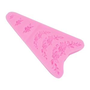 Détail macro d'un moule en silicone rose avec reliefs de roses et guirlandes de fleurs