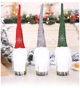 Detailed view of three plush Santa wine bottle covers with snowflake embroidery