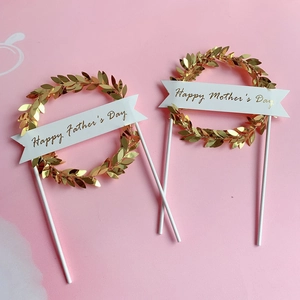 Golden acrylic leaf cake toppers for Father's and Mother's Day on pink background