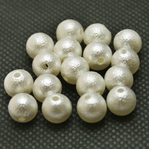 Dettaglio macro di perle bianche crema con fori per la creazione di gioielli fai da te