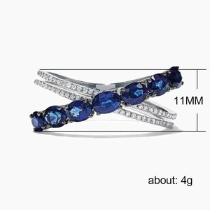 Crisscross silver ring with blue oval gemstones and clear pavé zircons, 11mm height