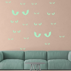 Luminous green glowing eyes wall stickers for Halloween room decor on pink wall