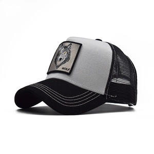 Detail of embroidered wolf patch on a black and grey breathable mesh trucker hat