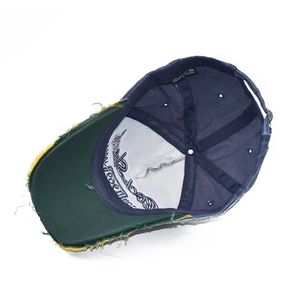 Dettaglio del cappellino vintage blu e verde con visiera consumata e cuciture interne
