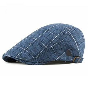 Close-up of blue plaid beret hat fabric texture with metallic adjustable side buckle