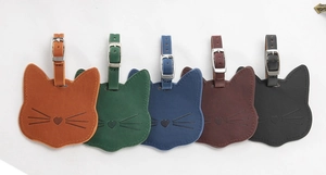Detailed view of cat-shaped leather luggage tags in five colors with metallic buckles