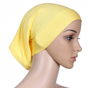 Side view of soft yellow mercerized cotton turban hat worn by a model on white background