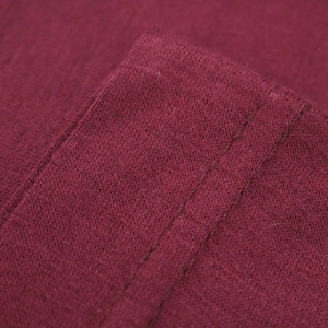 Detailed macro view of dark red mercerized cotton fabric texture and double stitching