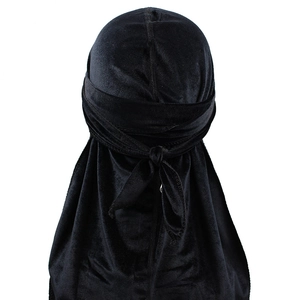 Detail view of black velvet durag back knots and long streamers on a white background