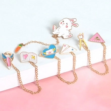 Cute macaron enamel pin set with bunny, planet, and school elements connected by gold chains