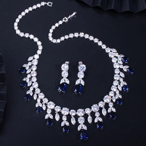 Détail d'un ensemble collier et boucles d'oreilles argenté avec pierres bleues