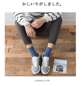 Close-up of blue cotton crew socks for men paired with sneakers on a wooden floor