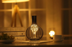 Detail of minimalist black metal wire lamp with warm LED copper string lights for home