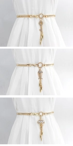 Detailed view of women's gold elastic metal belts with rhinestone leaf and fishbone charms