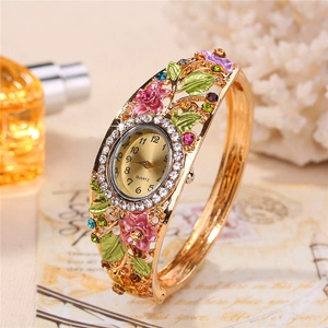 Macro detail of cloisonne floral bangle watch with pink enamel and crystals
