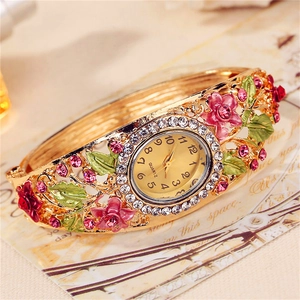 Macro shot of gold floral bangle watch with pink flowers and clear rhinestones detail