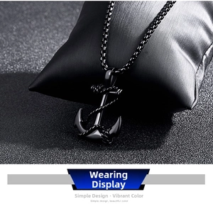 Détail du collier pendentif ancre noire avec textures de câble sur un coussin noir