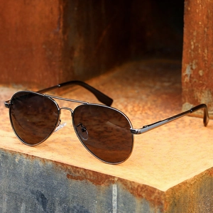 Classic aviator polarized sunglasses with dark grey lenses and gunmetal frame on industrial metal