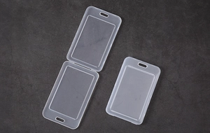 Macro shot of semi-transparent matte plastic card holder with lanyard hole on grey stone