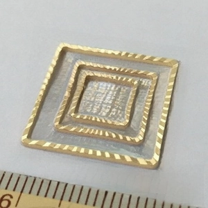 Macro shot of 14K gold plated square connector loops with detailed spiral texture