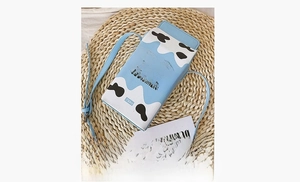 Detail of creative milk carton crossbody bag with cow pattern and pure milk text