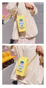 Detail view of a creative banana milk carton crossbody bag shown on a model outdoors