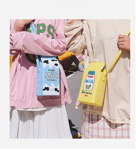 Detail of milk carton shaped crossbody bags in blue and yellow with creative prints