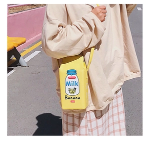Outdoor street shot of a model wearing the yellow banana milk carton crossbody bag