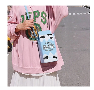 Detail of creative milk carton shaped shoulder bag with blue and white cow print texture