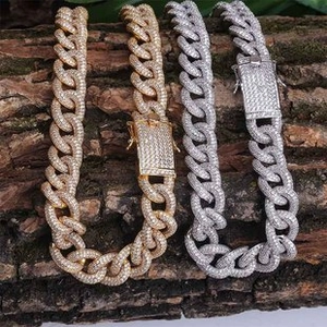 Close-up of gold and silver cuban link chains with zircon stones on natural bark texture