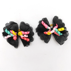 Detail of black lace pet hair bows with colorful spiral ribbons on white background